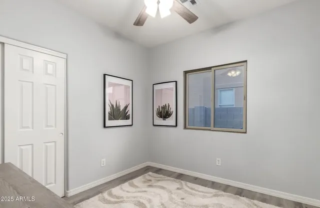 a view of a bedroom with wooden floor and chandelier fan