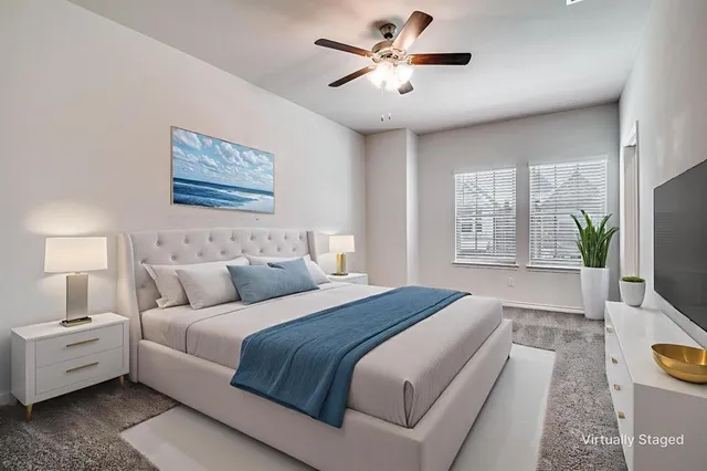 a spacious bedroom with a bed and a chandelier