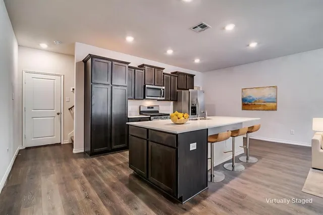 a kitchen with stainless steel appliances granite countertop a refrigerator a sink and a stove