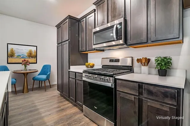 a kitchen with stainless steel appliances a stove a microwave sink and cabinets