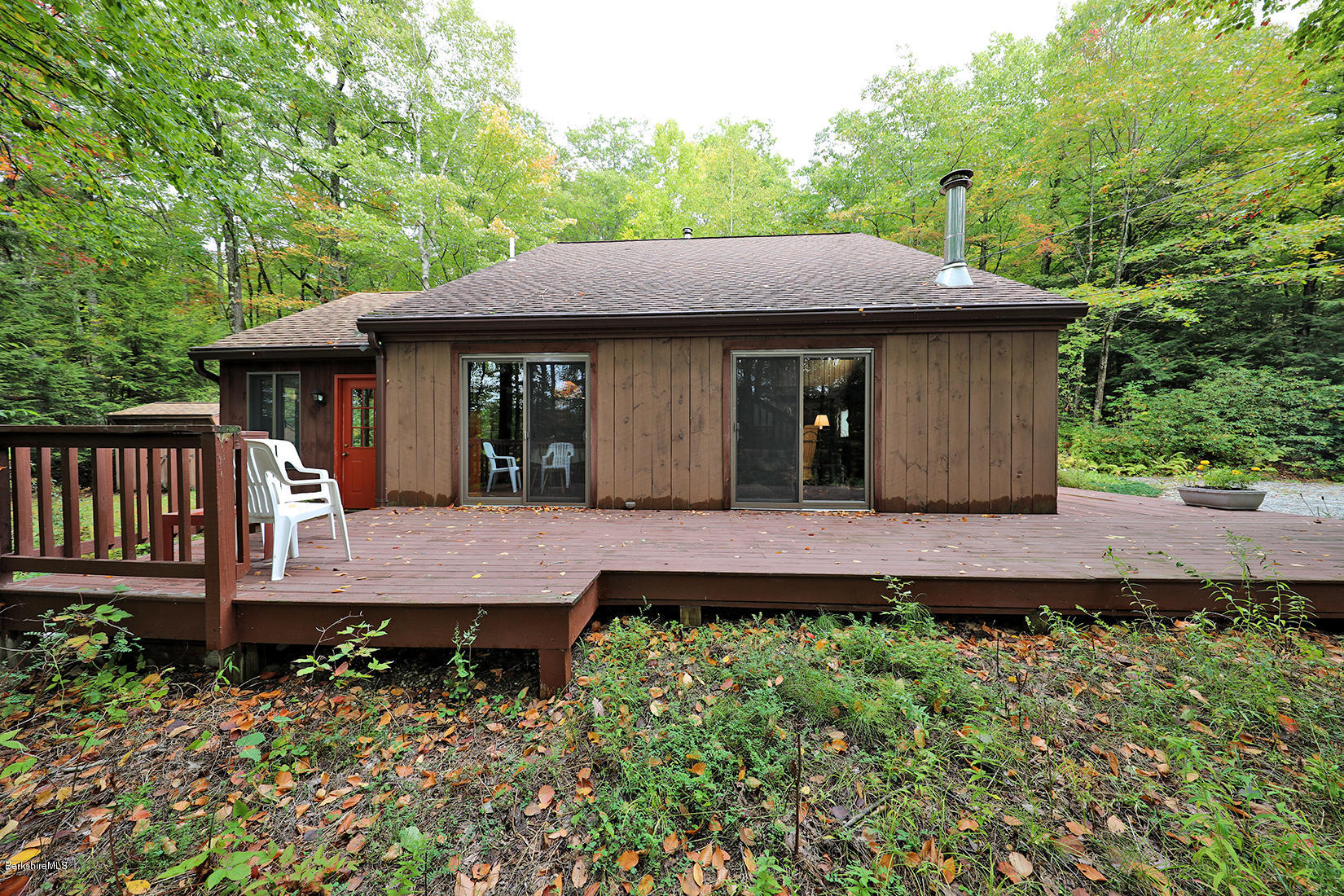 66 Ray Hubbard Road Otis, MA 01029 - Photo 20 of 21 a view of a house with wooden deck and furniture