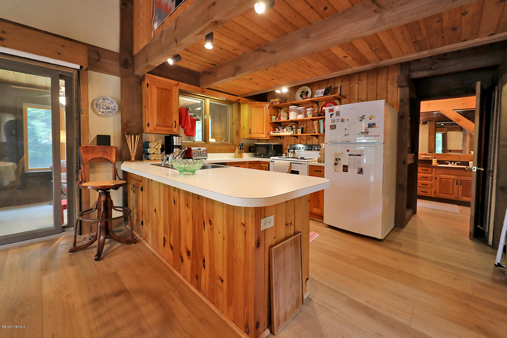 66 Ray Hubbard Road Otis, MA 01029 - Photo 4 of 21 a kitchen with stainless steel appliances a stove a refrigerator a sink dishwasher with a dining table and chairs with wooden floor