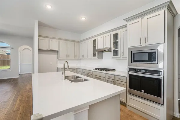 a kitchen with stainless steel appliances granite countertop a stove a sink and a microwave