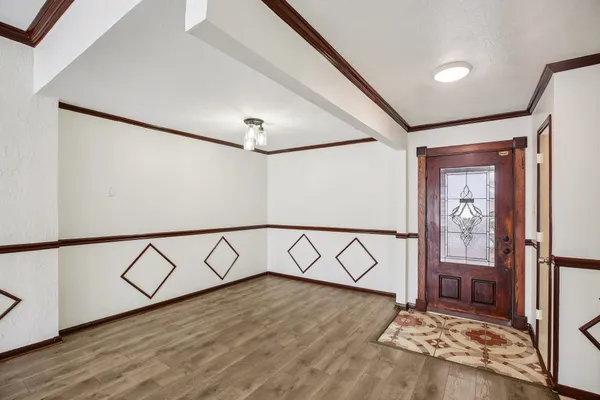 an empty room with wooden floor closet fan and windows