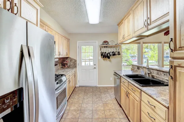 a kitchen with granite countertop a refrigerator and a sink