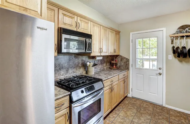 a kitchen with stainless steel appliances granite countertop a stove a sink and a microwave