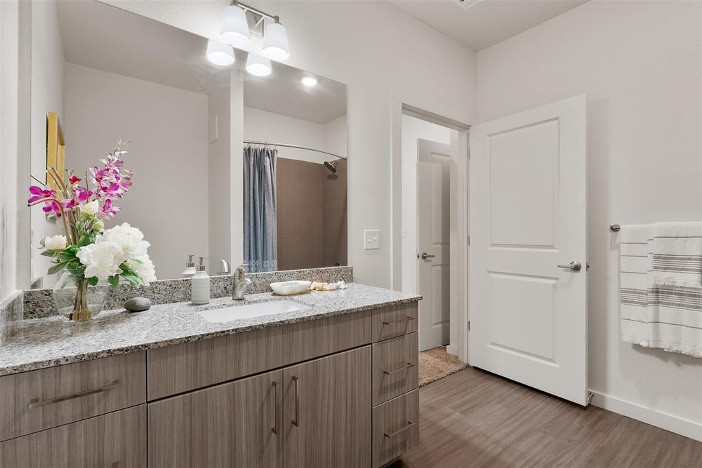 13301 Dessau Road, Unit 7203 Austin, TX 78754 - Photo 8 of 17 a bathroom with a granite countertop sink a large mirror and a shower