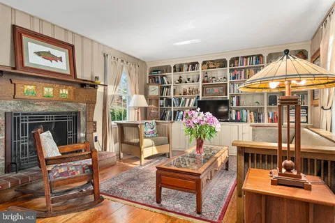 a living room with furniture a fireplace and a chandelier