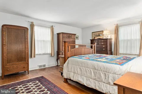 a bedroom with two beds and a chair