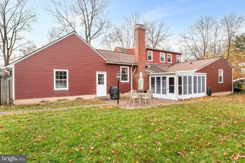 a white house that has a big yard with wooden fence