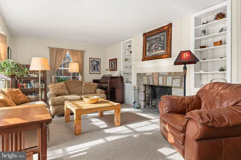 a living room with furniture a fireplace and a large window