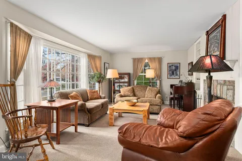 a living room with furniture a fireplace and a large window