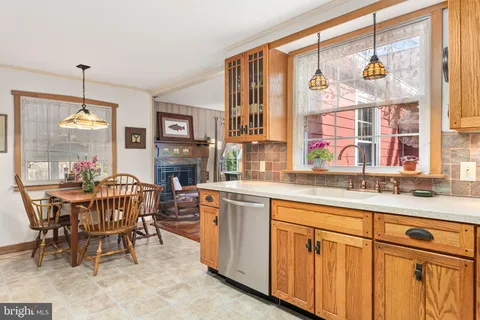 a kitchen with stainless steel appliances granite countertop a table and chairs in it