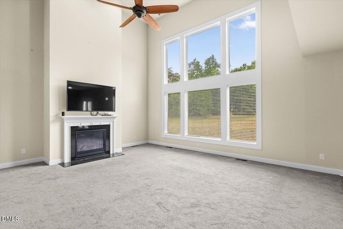 704 Haw River Hopedale Road Burlington, NC 27217 - Photo 14 of 49 a view of an empty room with a fireplace and a window