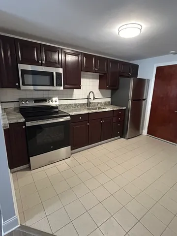 a kitchen with stainless steel appliances granite countertop a sink and stove top oven