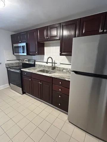 a kitchen with stainless steel appliances granite countertop a refrigerator and a sink