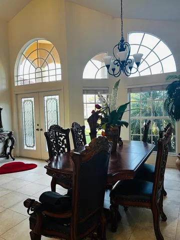 a view of a dining room and a livingroom with furniture wooden floor a chandelier