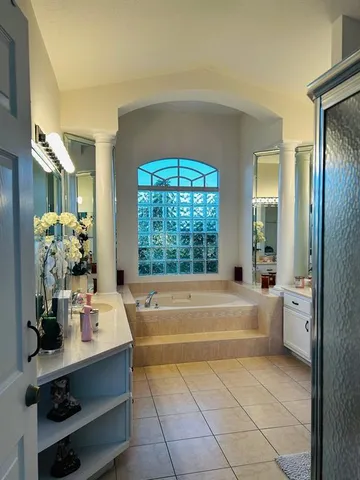 a bathroom with a tub sink and mirror