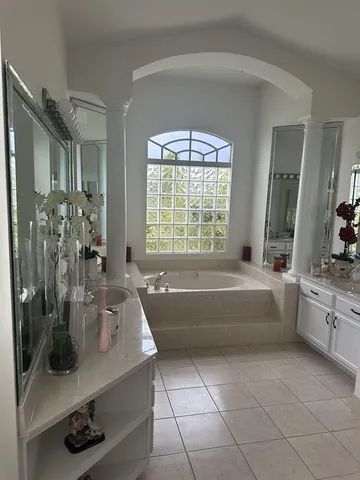 a spacious bathroom with a double vanity sink a large mirror and bathtub
