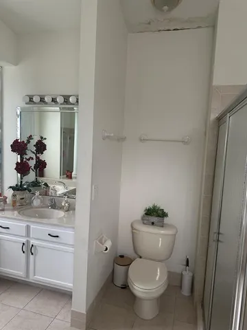 a bathroom with a granite countertop toilet a sink and a mirror