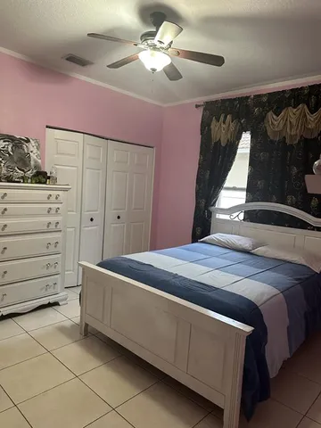 a bed room with a bed and a ceiling fan