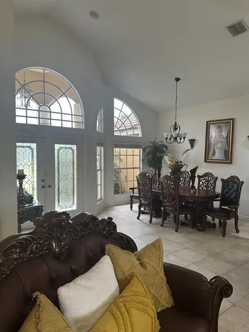 a living room with furniture chandelier and a large window