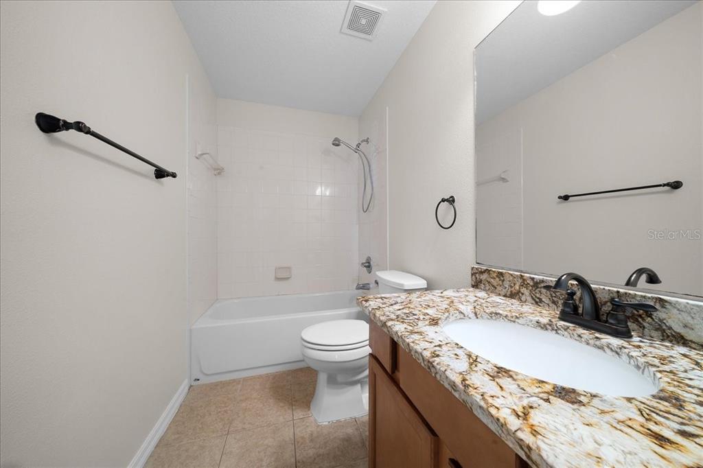 234 Locust Lane Ocala, FL 34472 - Photo 66 of 71 a bathroom with a granite countertop sink a toilet and a mirror