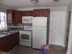 a kitchen with a refrigerator sink and cabinets