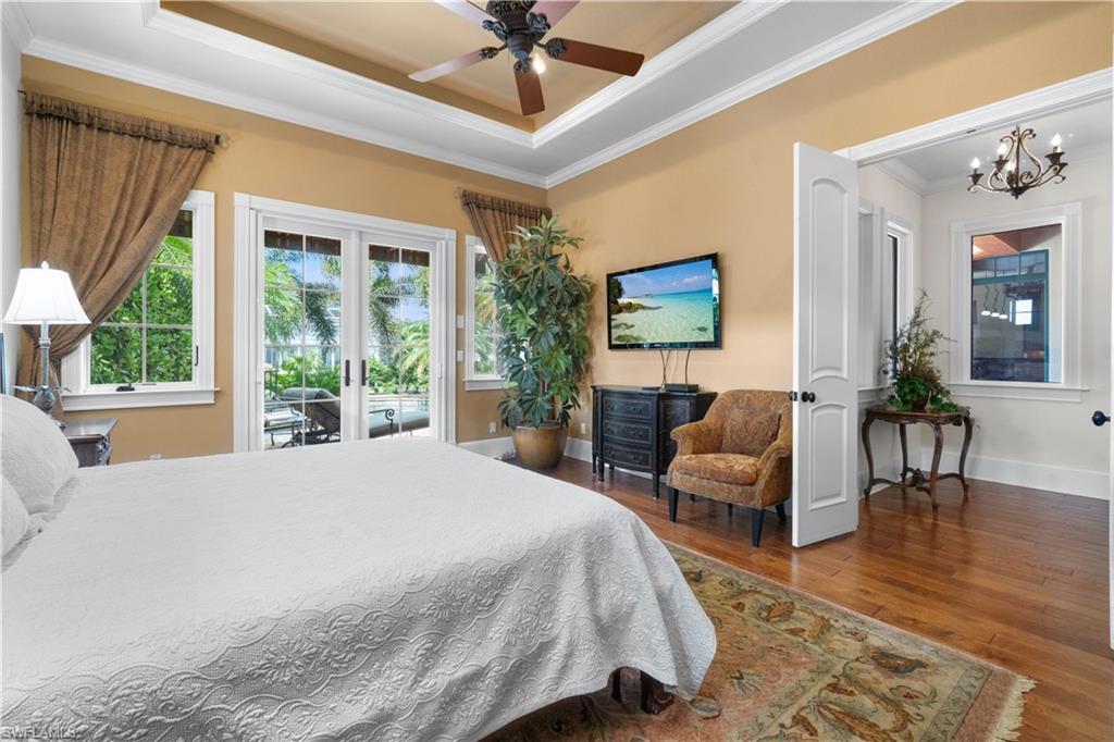 611 18th Avenue South Naples, FL 34102 - Photo 13 of 32 a spacious bedroom with a large bed a flat screen tv and a couch