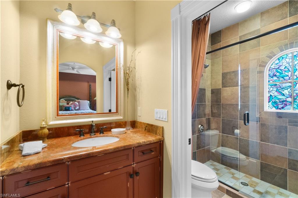 611 18th Avenue South Naples, FL 34102 - Photo 19 of 32 a bathroom with a granite countertop sink toilet mirror and shower