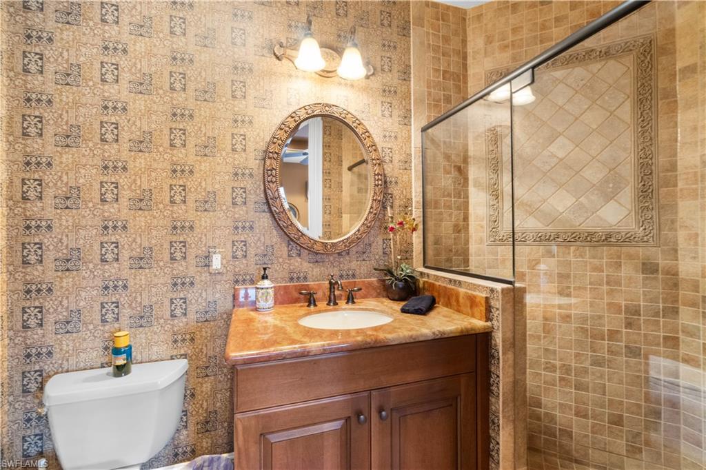 611 18th Avenue South Naples, FL 34102 - Photo 22 of 32 a bathroom with a sink and a mirror