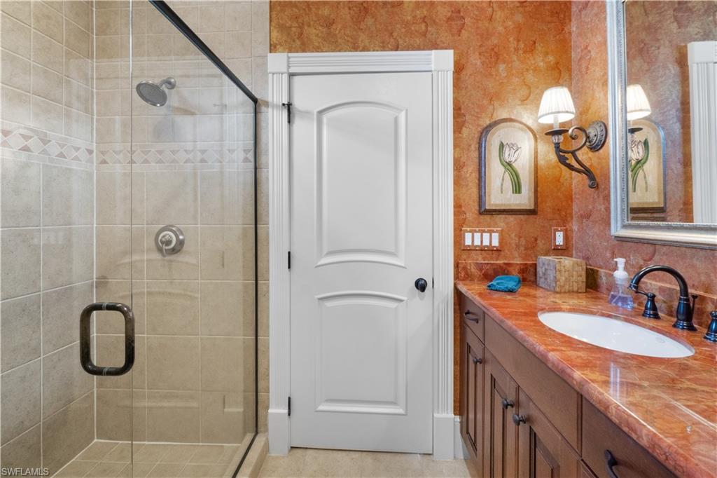 611 18th Avenue South Naples, FL 34102 - Photo 23 of 32 a bathroom with a granite countertop shower a mirror and a sink