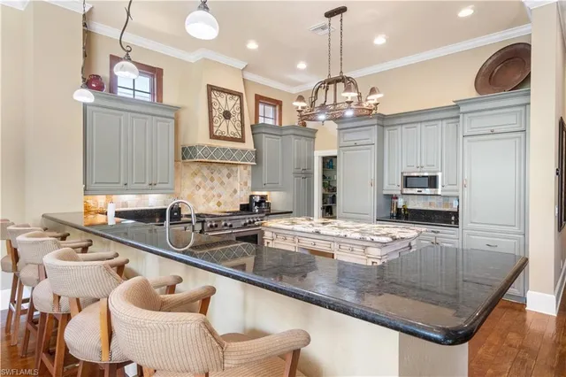 a kitchen with granite countertop a sink a counter top space appliances and cabinets