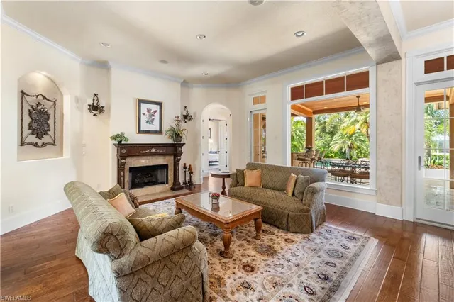 a living room with furniture a dining table and a chandelier