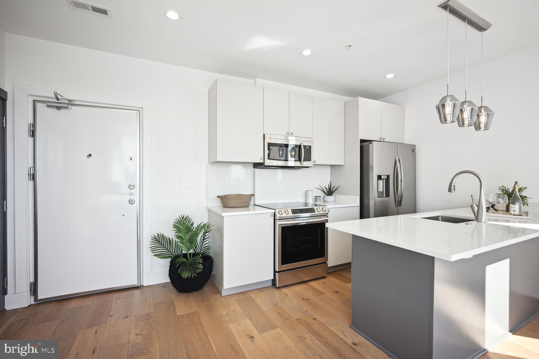 3619 Georgia Avenue Northwest, Unit 405 Washington, DC 20010 - Photo 4 of 16 a kitchen with stainless steel appliances kitchen island granite countertop a refrigerator and a sink