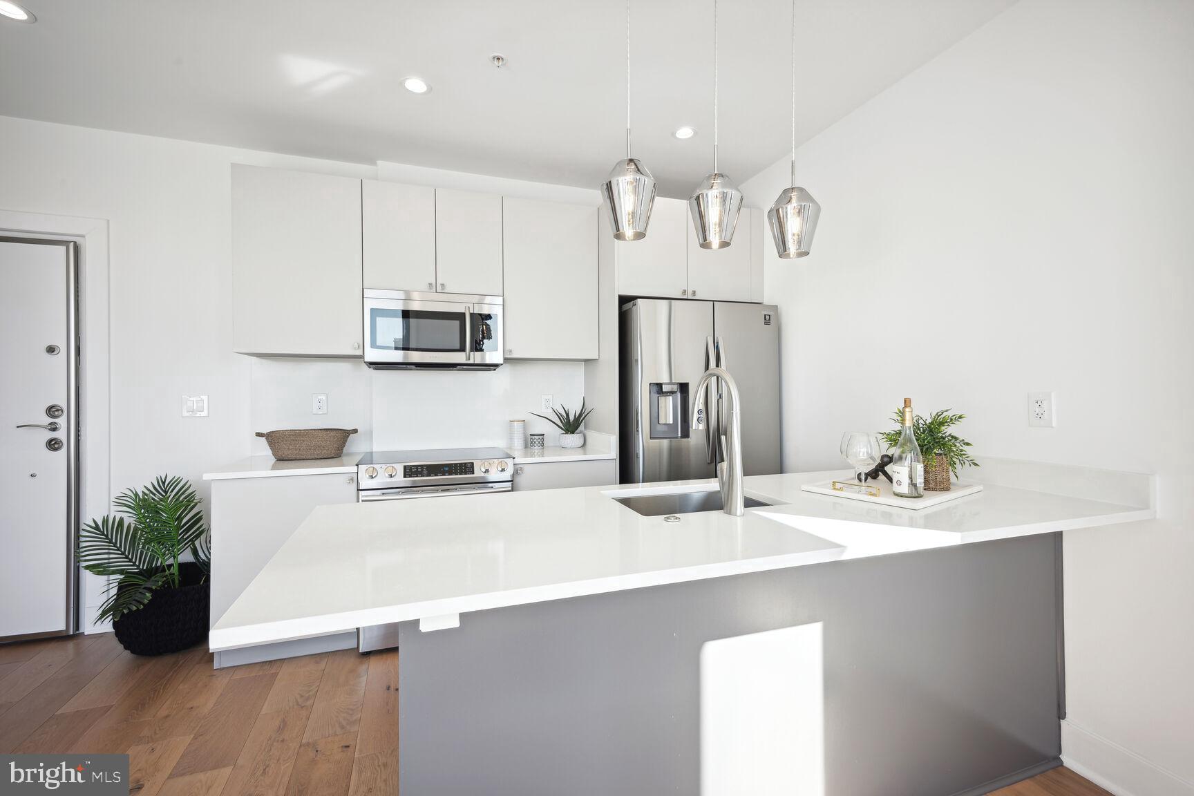 3619 Georgia Avenue Northwest, Unit 405 Washington, DC 20010 - Photo 6 of 16 a kitchen with kitchen island a sink stainless steel appliances and refrigerator