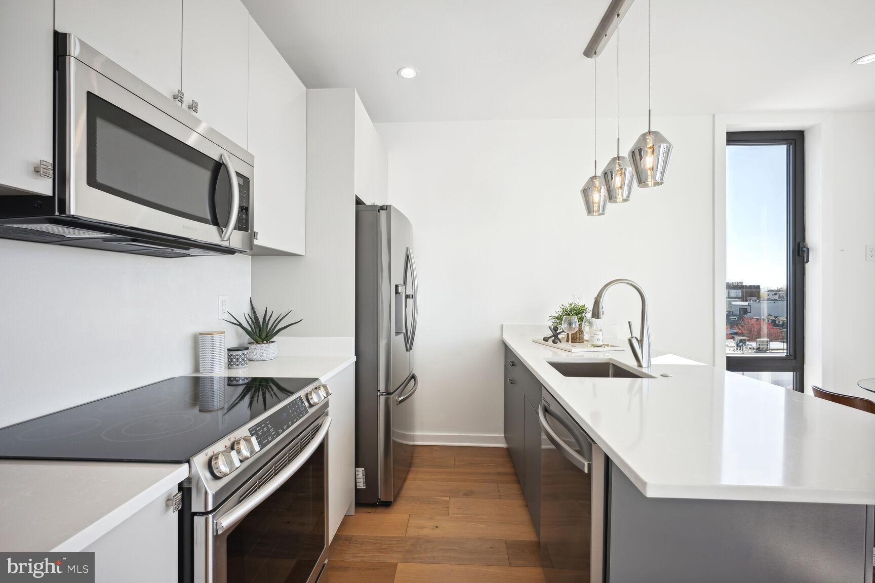 3619 Georgia Avenue Northwest, Unit 405 Washington, DC 20010 - Photo 8 of 16 a kitchen with stainless steel appliances granite countertop a sink and a microwave