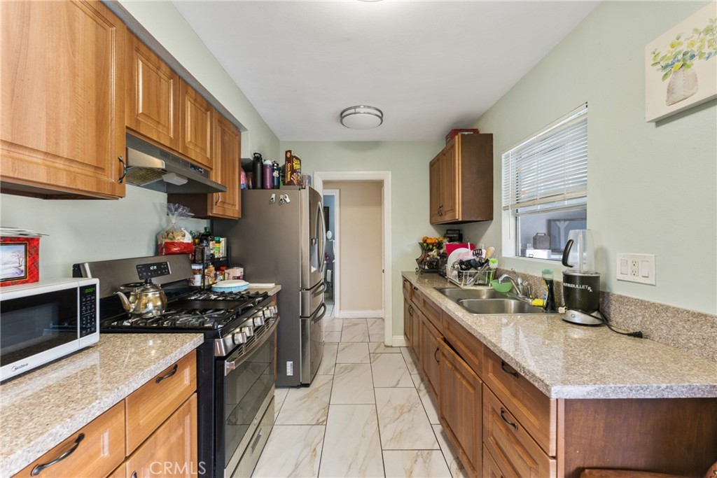 276 East Merrill Avenue Rialto, CA 92376 - Photo 12 of 35 a kitchen with granite countertop a sink stove and refrigerator