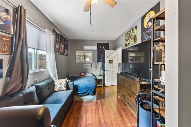 a living room with furniture a flat screen tv and a floor to ceiling window