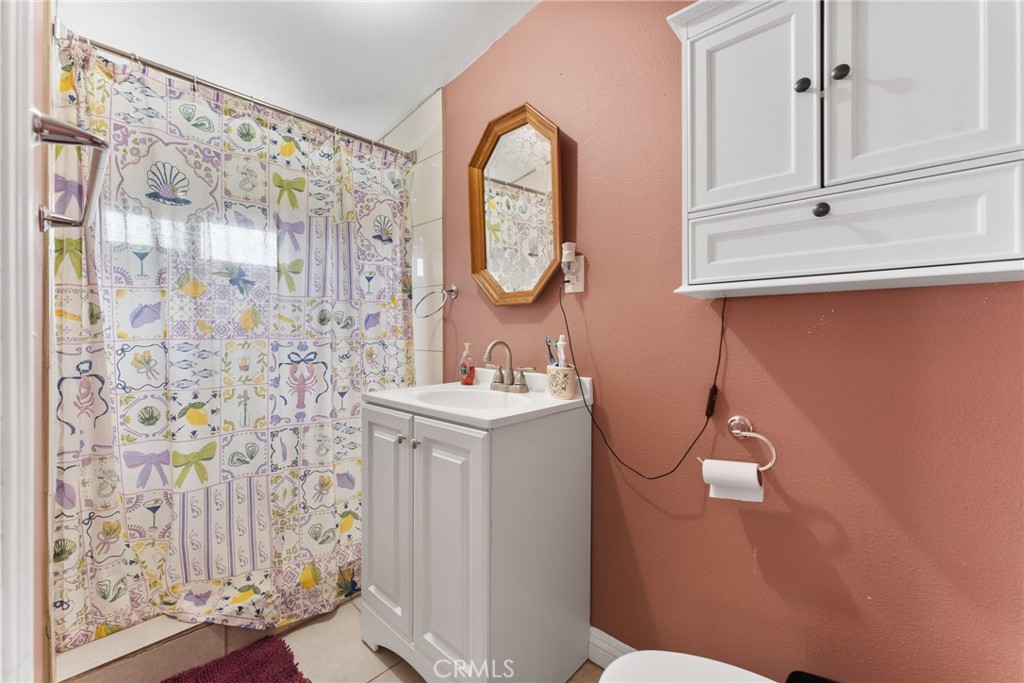 276 East Merrill Avenue Rialto, CA 92376 - Photo 25 of 35 a bathroom with a sink a toilet and a shower curtain