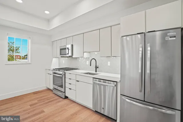 a kitchen with stainless steel appliances granite countertop a refrigerator sink and stove