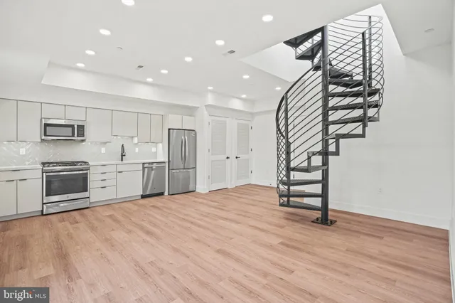 a kitchen with stainless steel appliances a refrigerator and a stove top oven