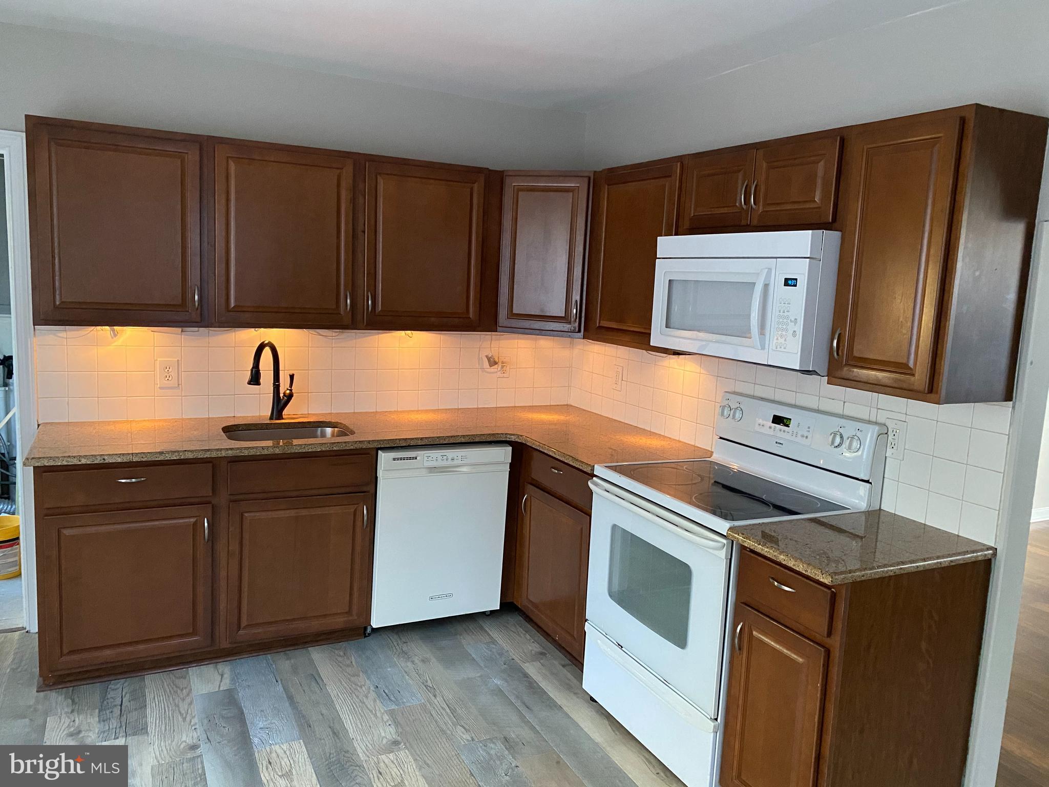 1171 West County Line Road Hatboro, PA 19040 - Photo 6 of 22 a kitchen with stainless steel appliances granite countertop white cabinets a microwave a sink and dishwasher