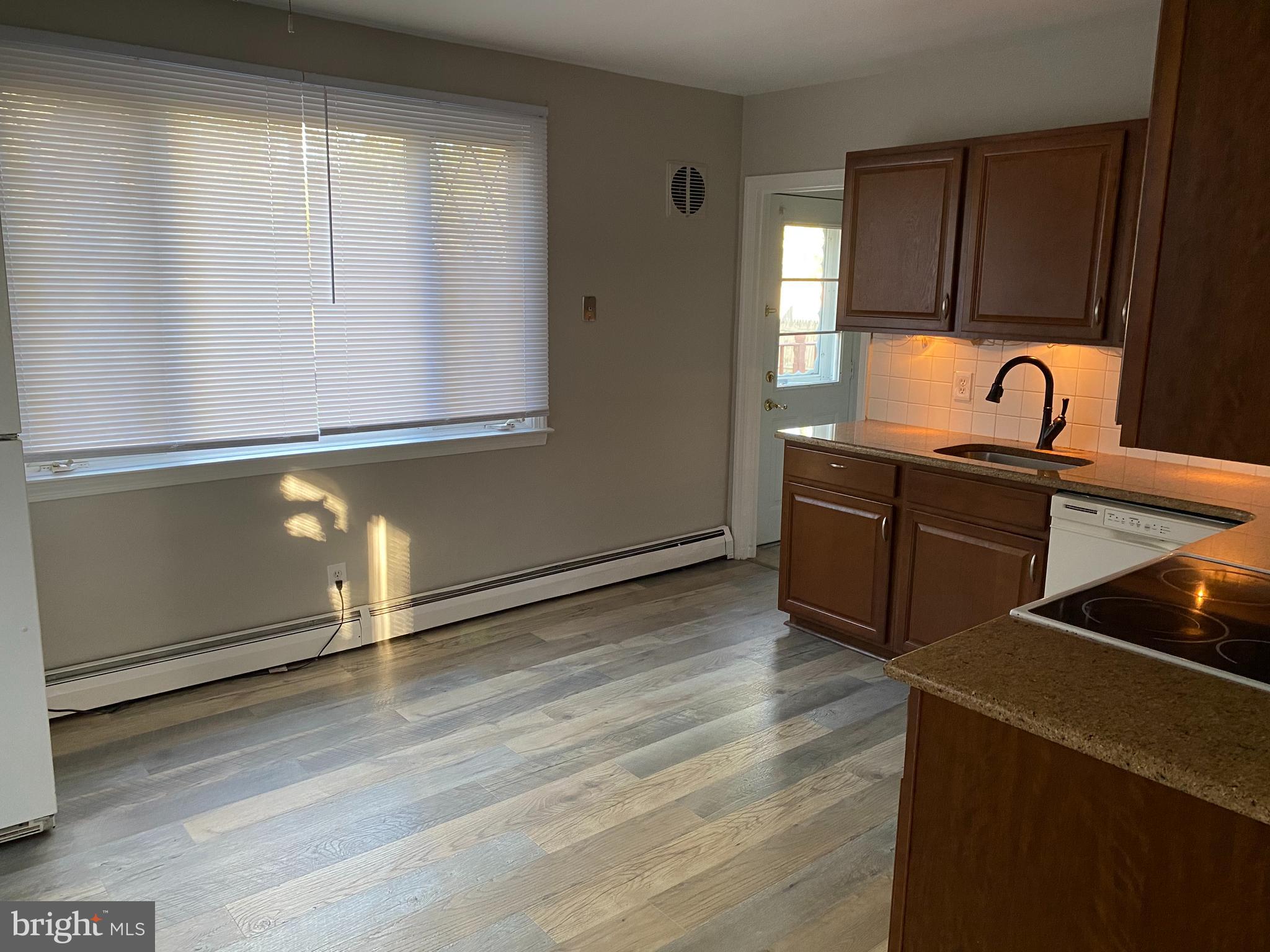 1171 West County Line Road Hatboro, PA 19040 - Photo 8 of 22 a kitchen with stainless steel appliances granite countertop a sink a stove with wooden floors