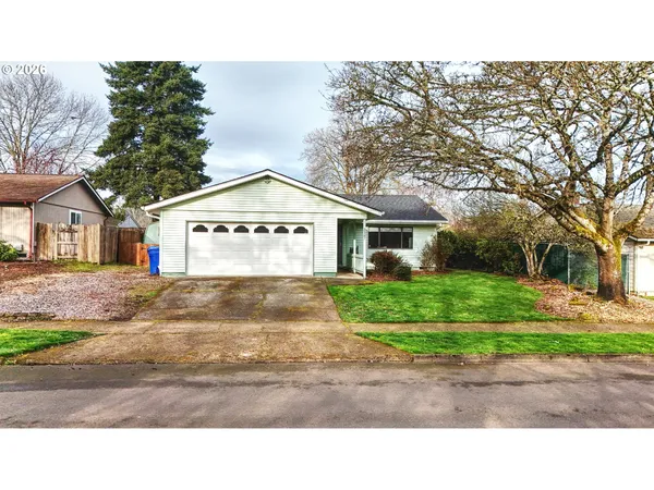 a view of a house with a yard and large tree