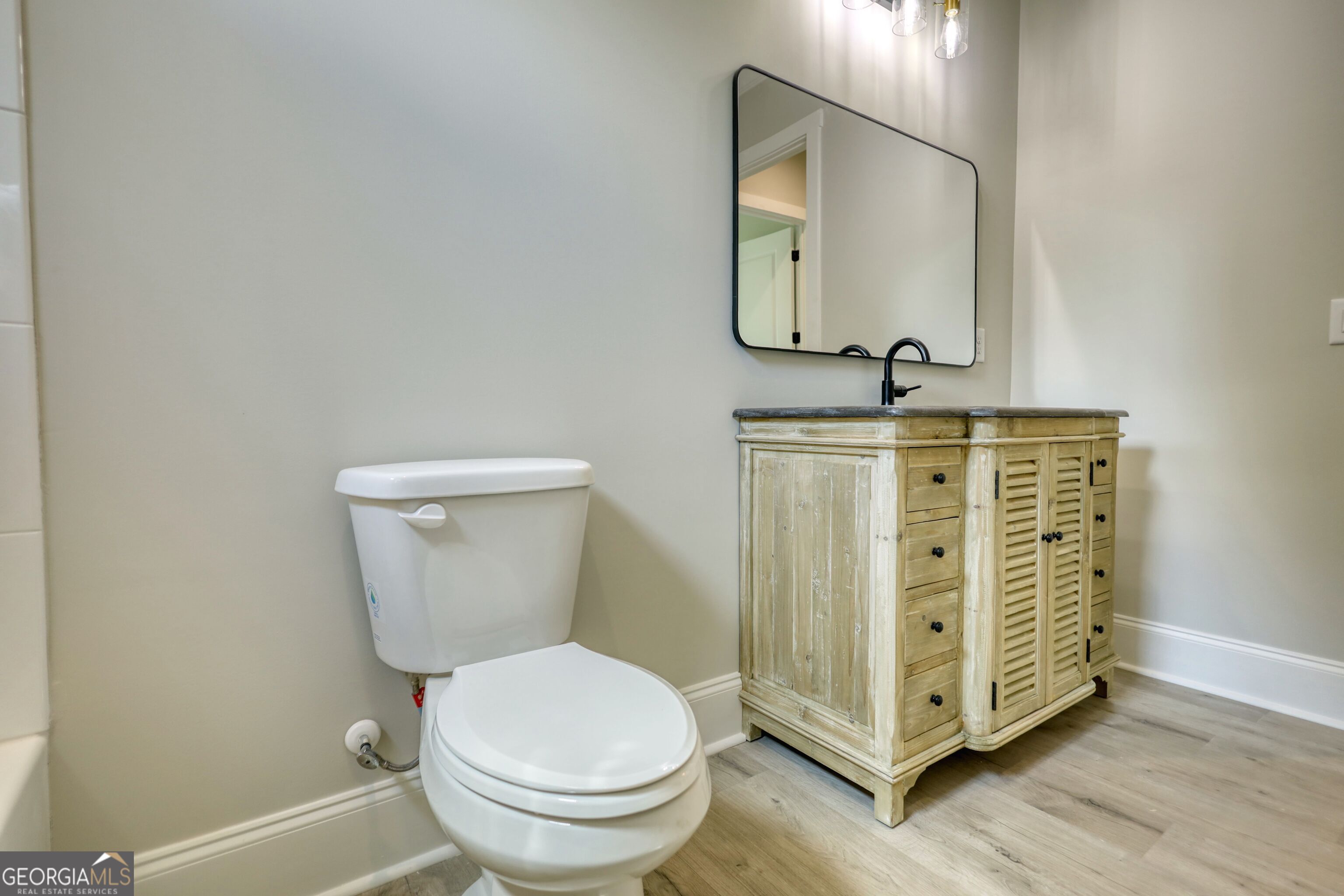 1031 Graham Drive Madison, GA 30650 - Photo 24 of 78 a bathroom with a toilet a sink and mirror