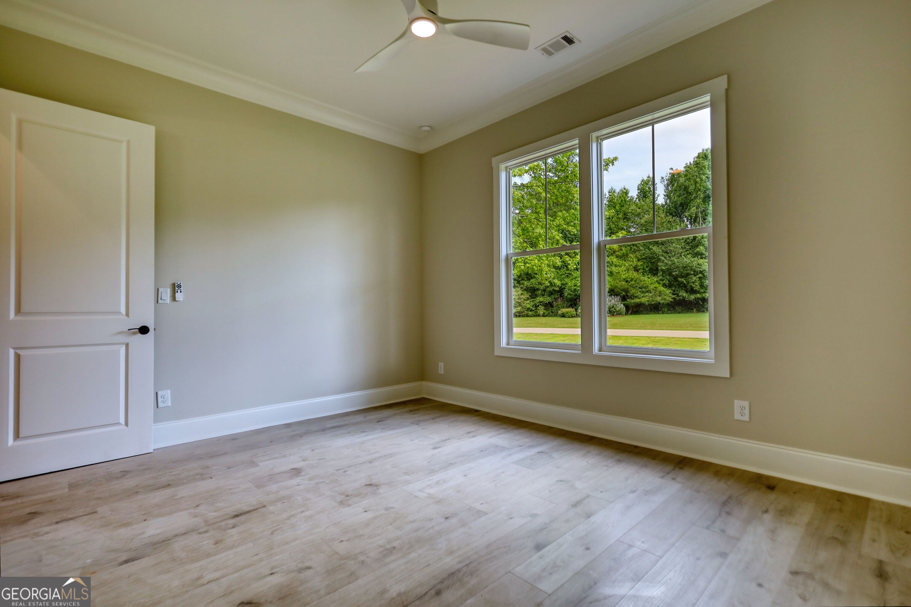 1031 Graham Drive Madison, GA 30650 - Photo 28 of 78 a view of an empty room with wooden floor and a window