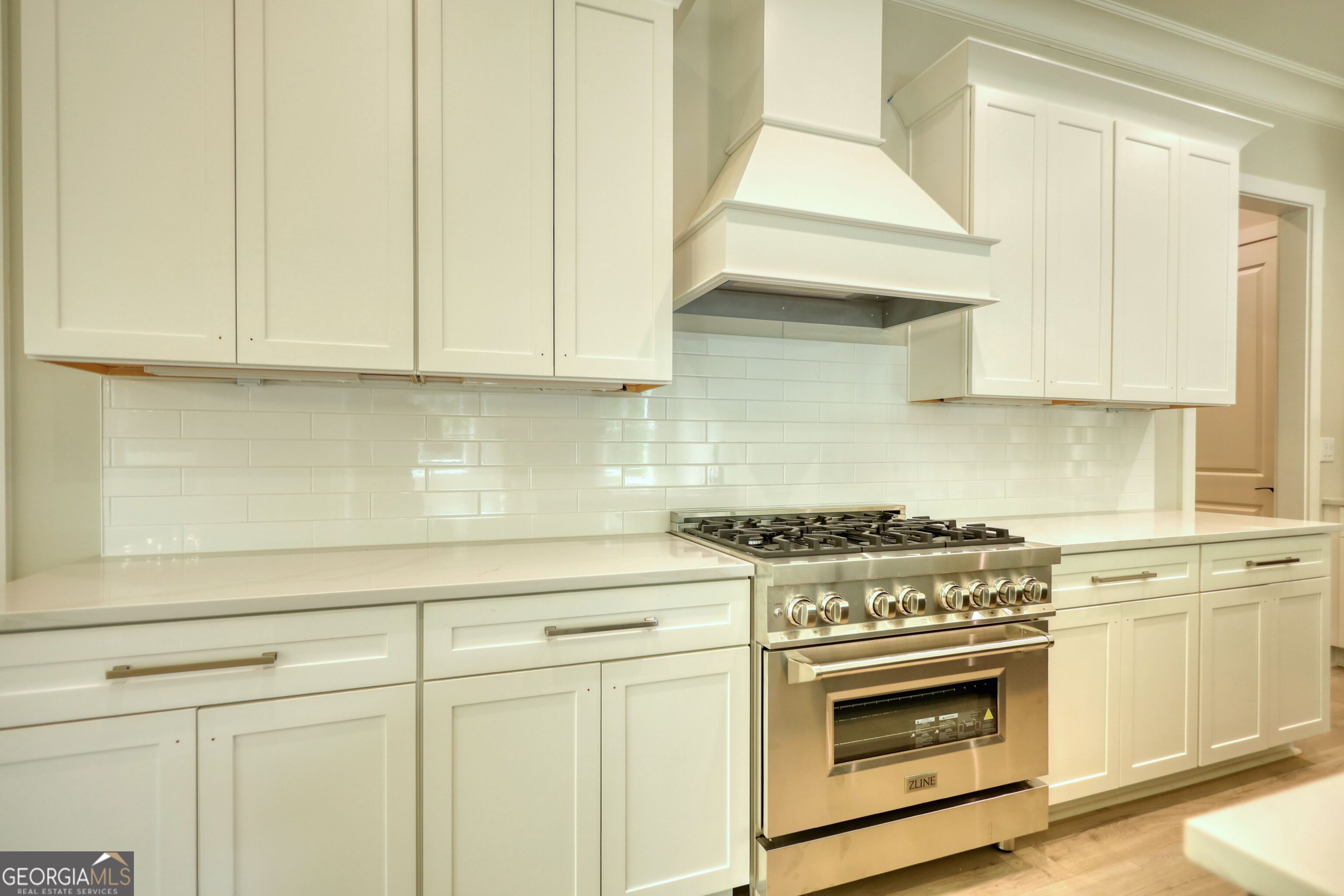 1031 Graham Drive Madison, GA 30650 - Photo 34 of 78 a kitchen with granite countertop white cabinets and white appliances