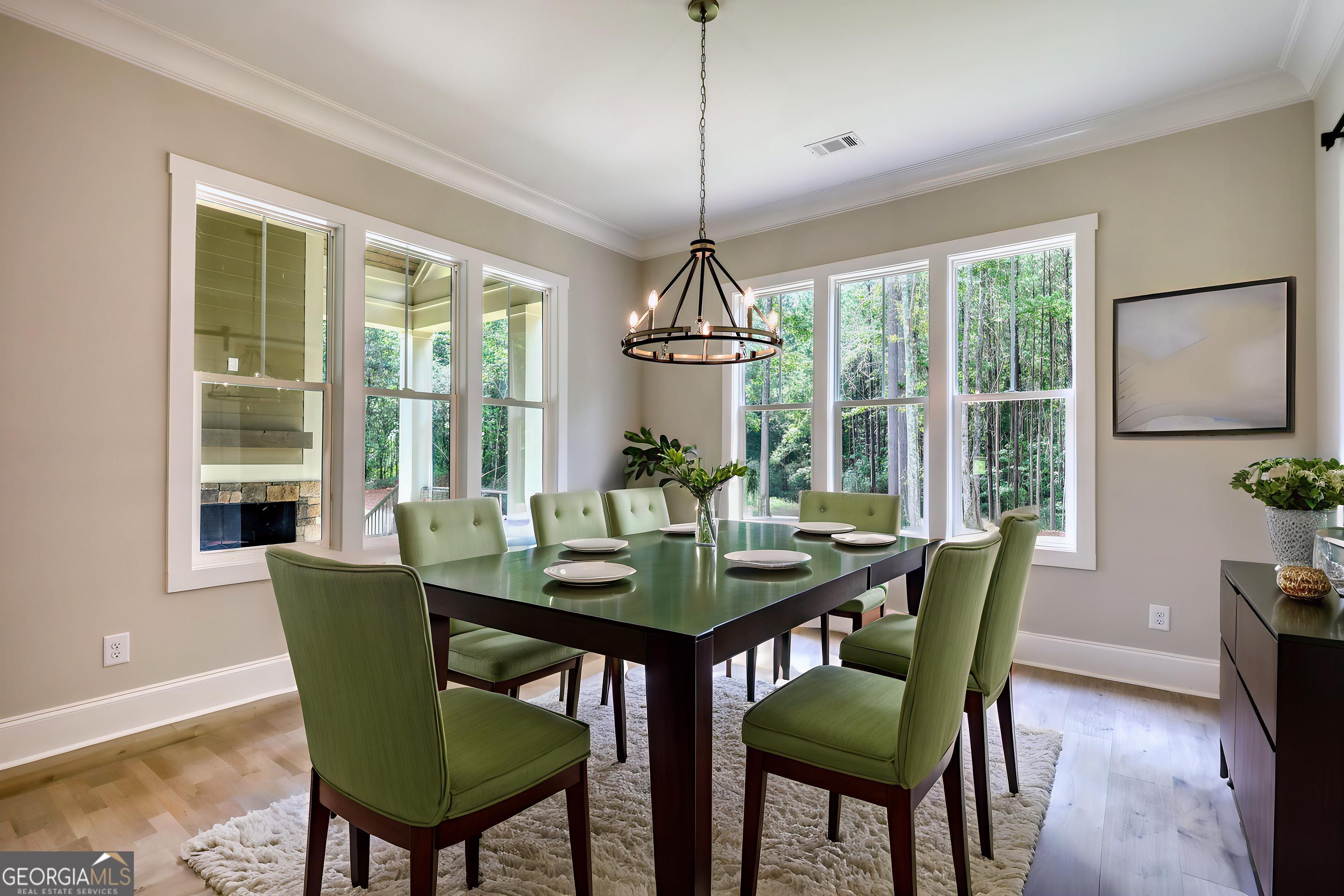 1031 Graham Drive Madison, GA 30650 - Photo 46 of 78 a dining room with furniture a chandelier and wooden floor