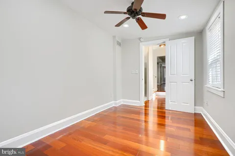 a view of empty room with wooden floor and window